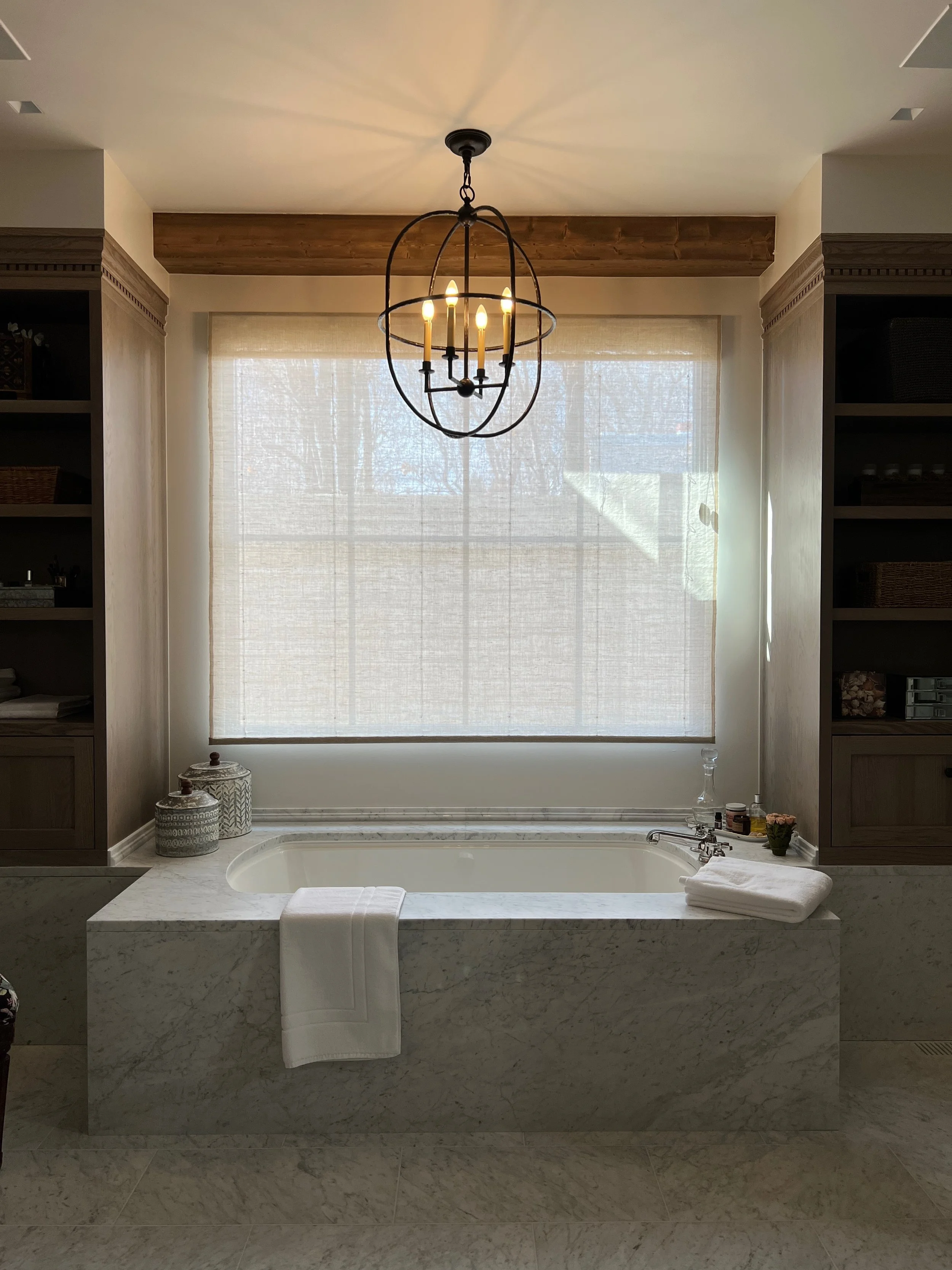 Luxury primary bathroom renovation in Denver by Studio Rhodes with a marble soaking tub, custom built-ins, and layered lighting for a spa-like retreat.