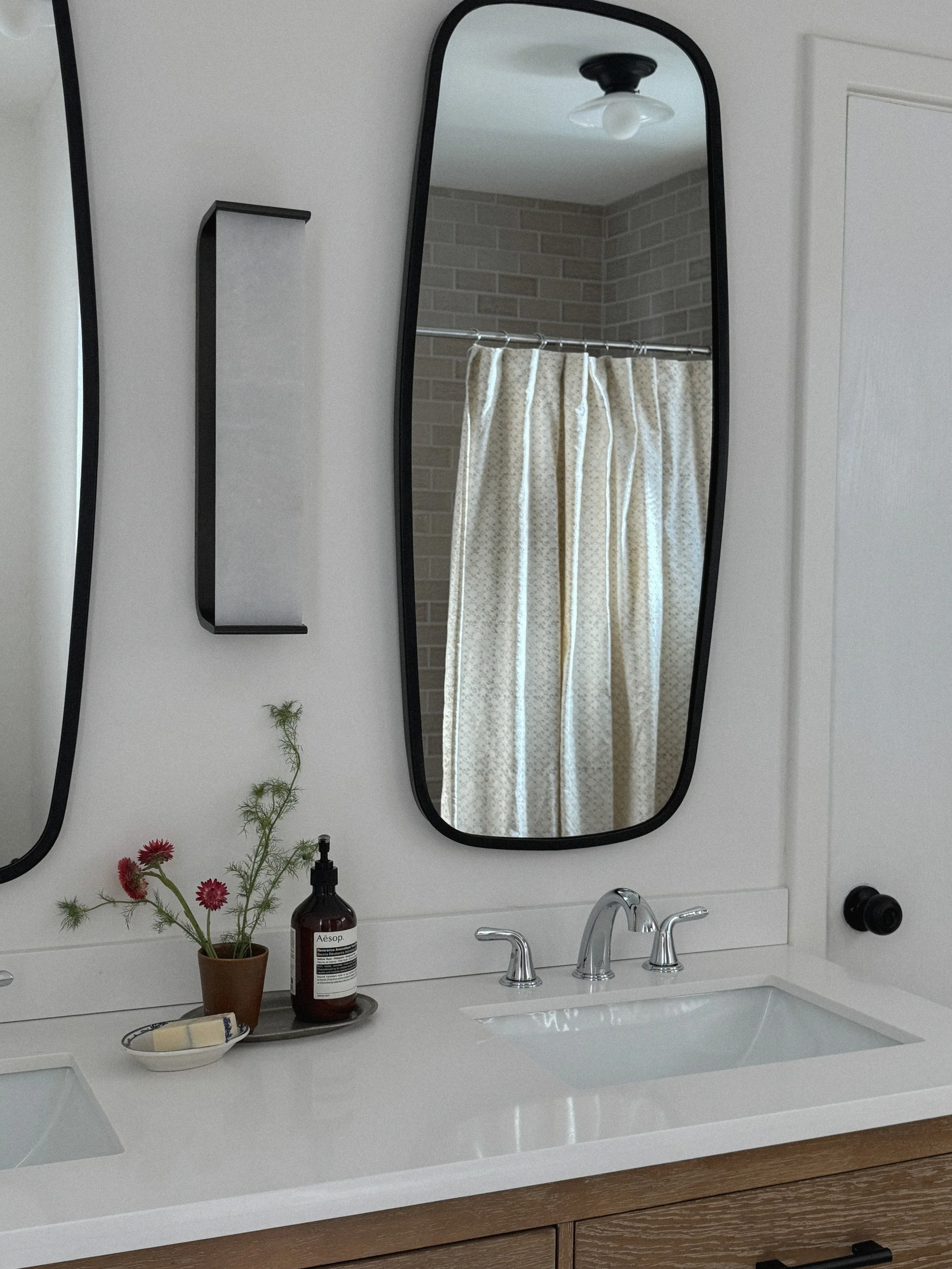 Mountain modern bathroom remodel and interior design with brick shower tile, alabaster wall sconce, natural oak vanity and under mount sinks