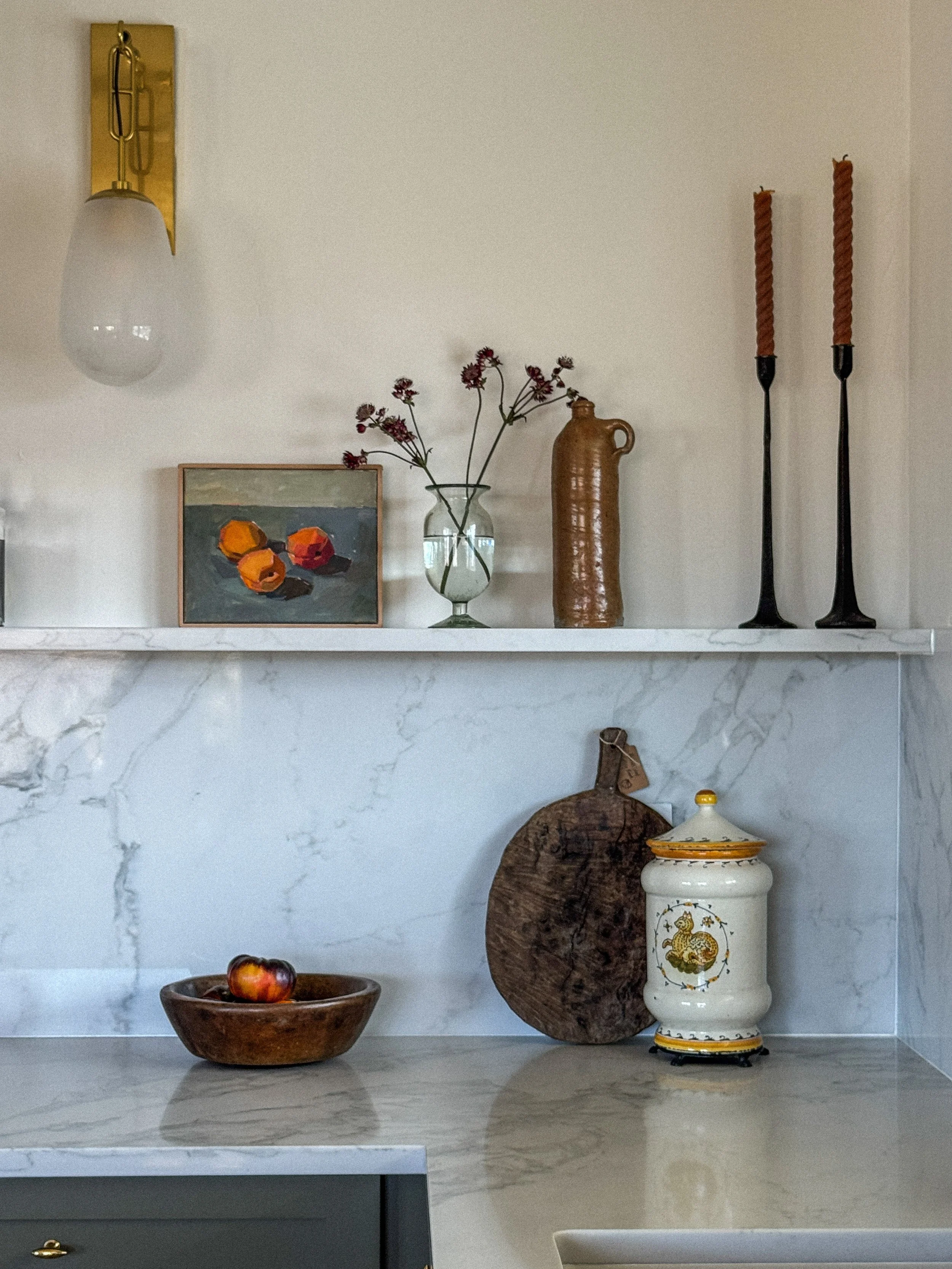 Detail image of mountain modern kitchen shelf styling in Steamboat Springs, Colorado featuring sage green cabinets and unlacquered brass