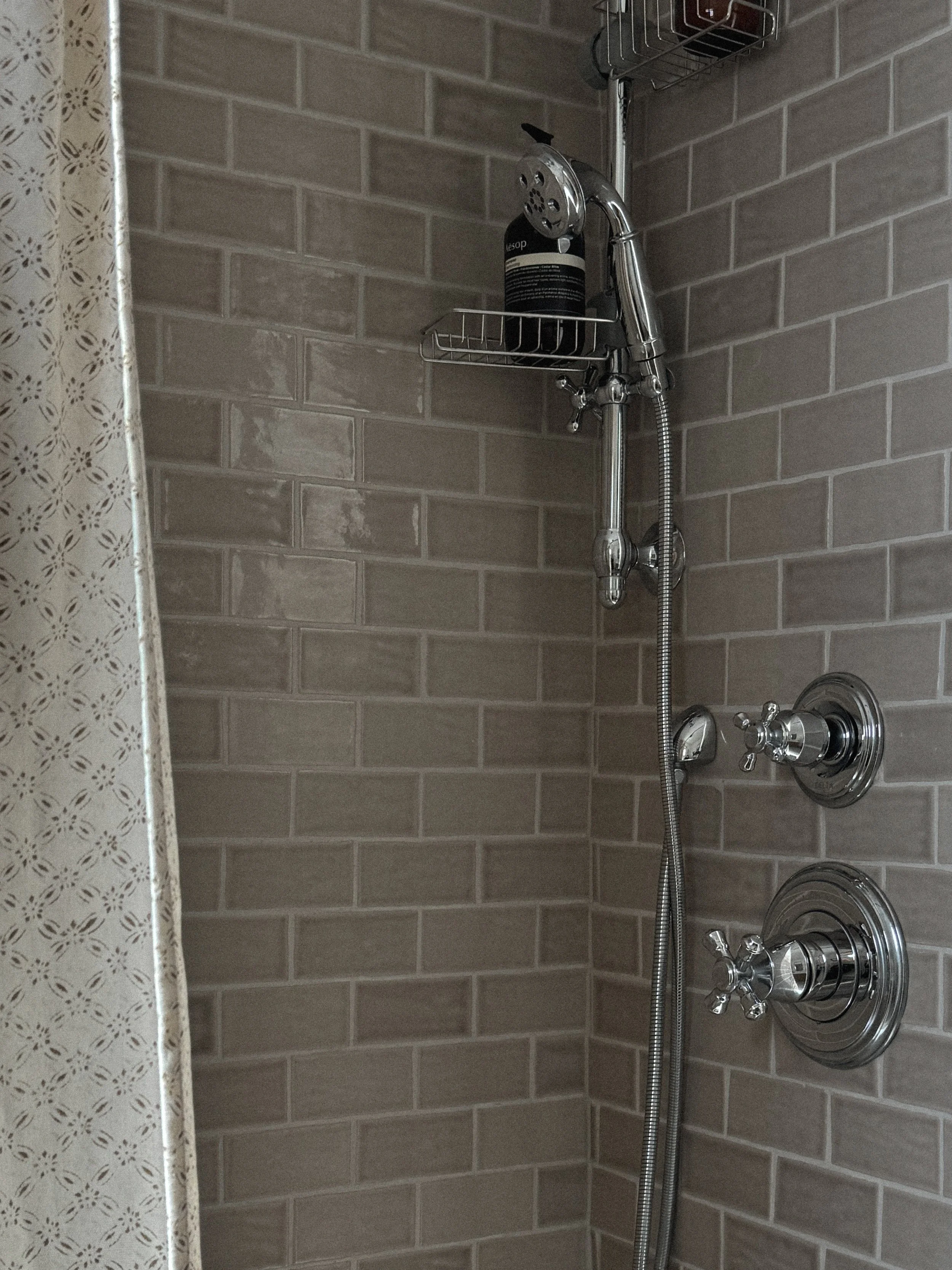 mountain interior design bathroom remodel in Steamboat Springs, Colorado, featuring handmade ceramic tile, vintage plumbing fixtures & patterned shower curtain