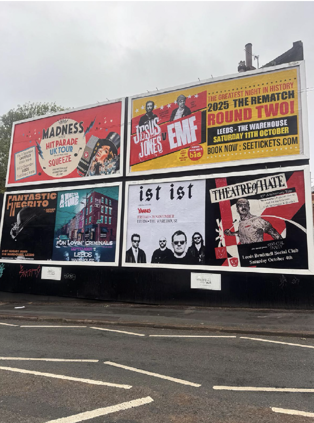 Billboard advertisements for various music and entertainment events in Leeds, including a Madness UK tour, Jesus Jones and EMF, and other local shows.