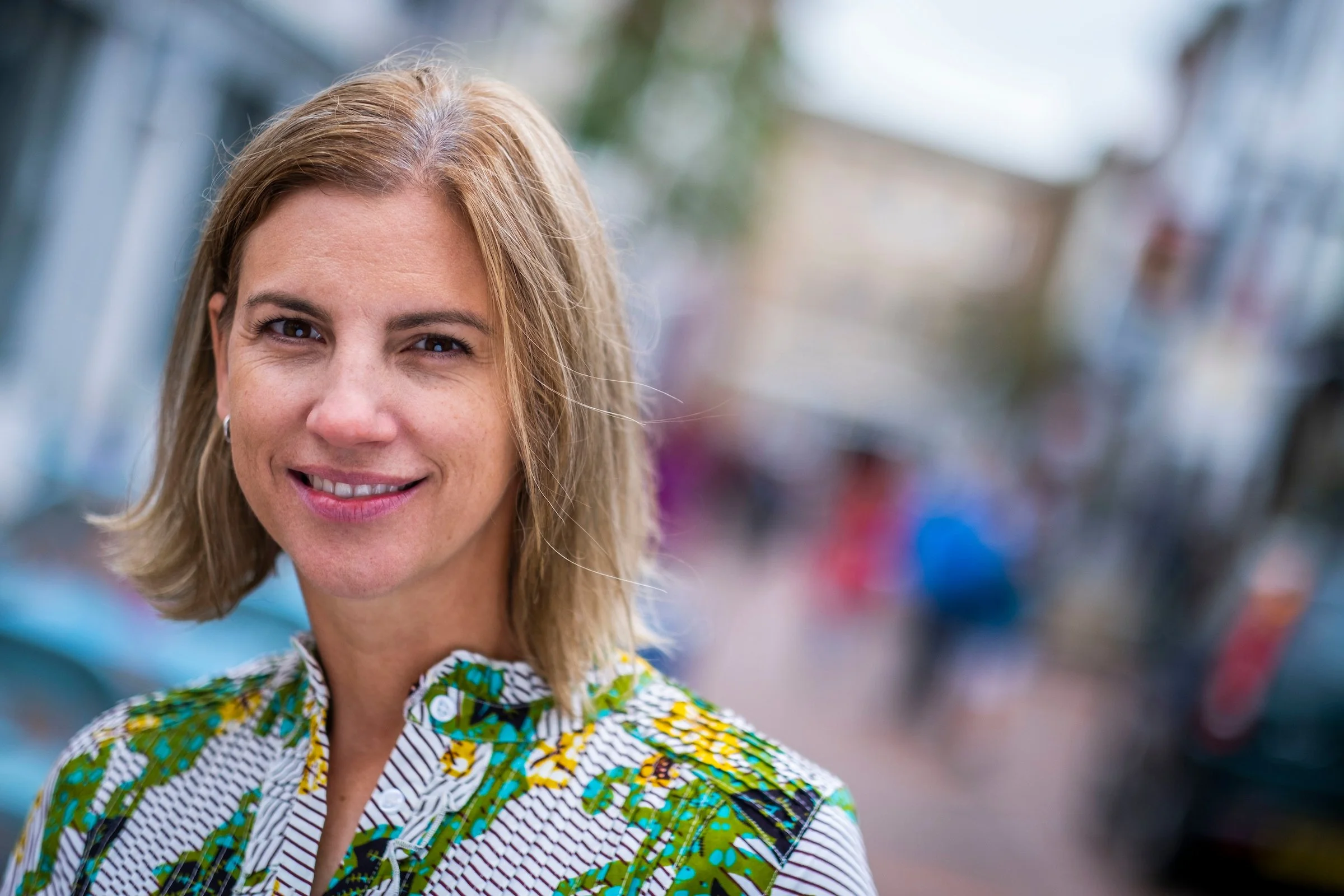 A photo of Eleanot Tweddell, a woman with blonde hair, wearing a floral blouse in green and yellow.