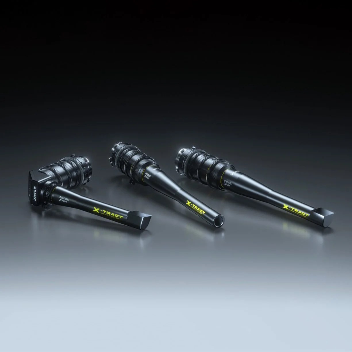 Three professional zoom lenses with black bodies and yellow branding, laid out on a surface with a dark gradient background.