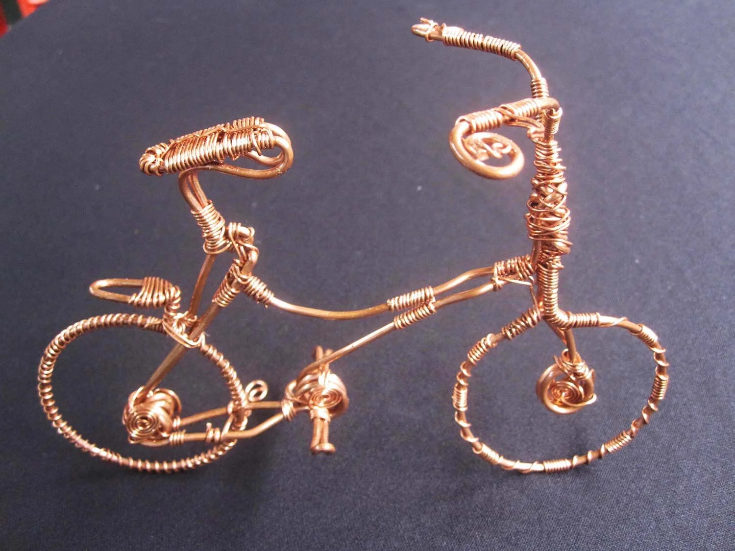 Recycled Copper Bicycles-various forms of miniature bicycle figures, created out of recycled copper wire