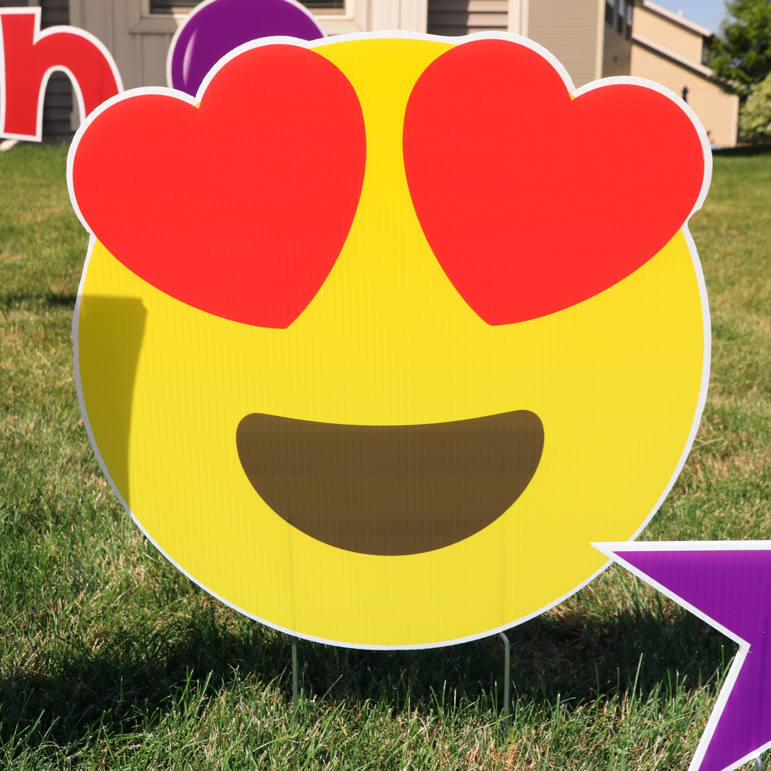 Heart eyes emoji yard sign on grass