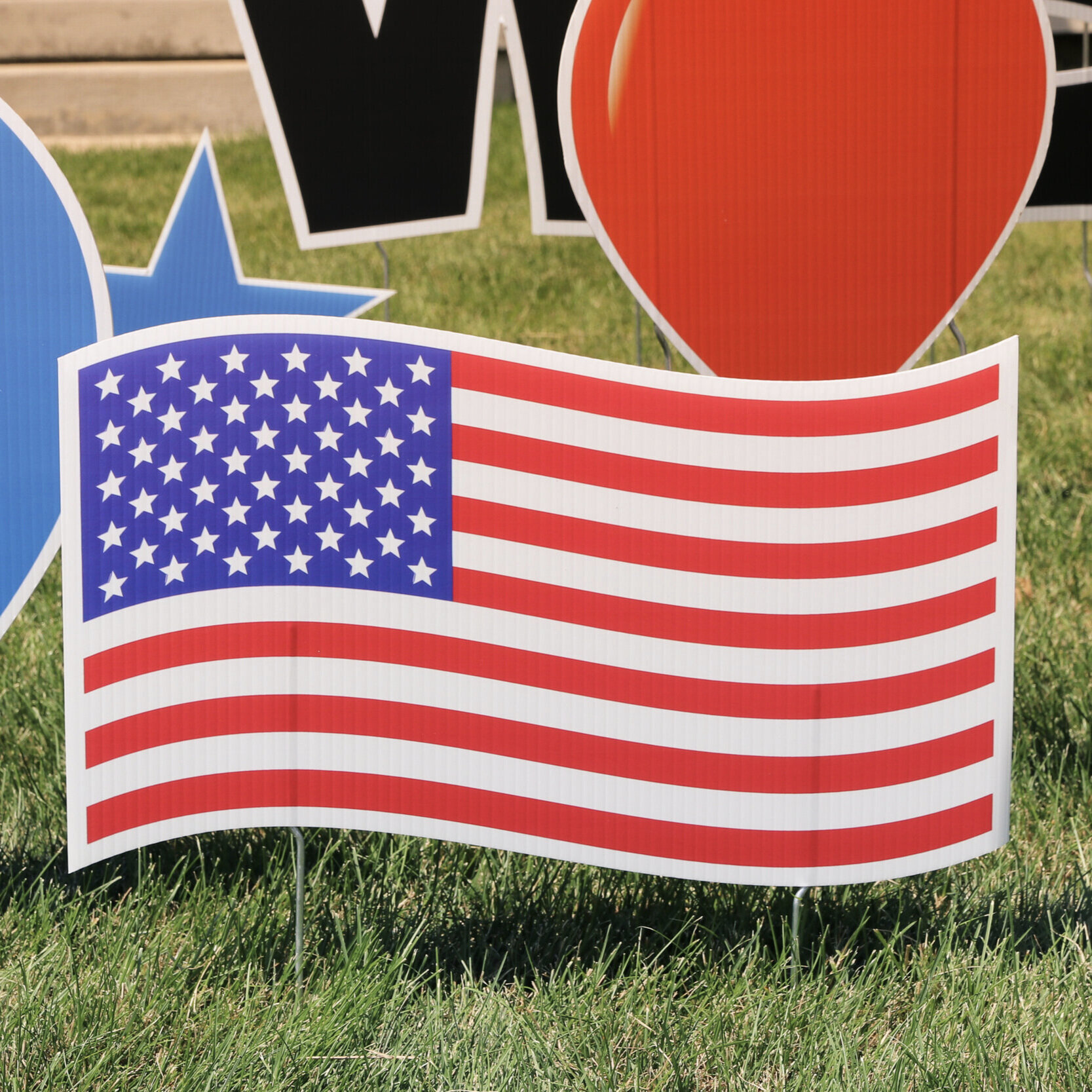 Decorative sign featuring the American flag on grass