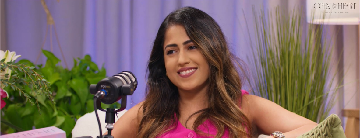 Rosy Thachil, MD, MBA, FACC, smiling and talking into a microphone during an indoor interview or podcast.