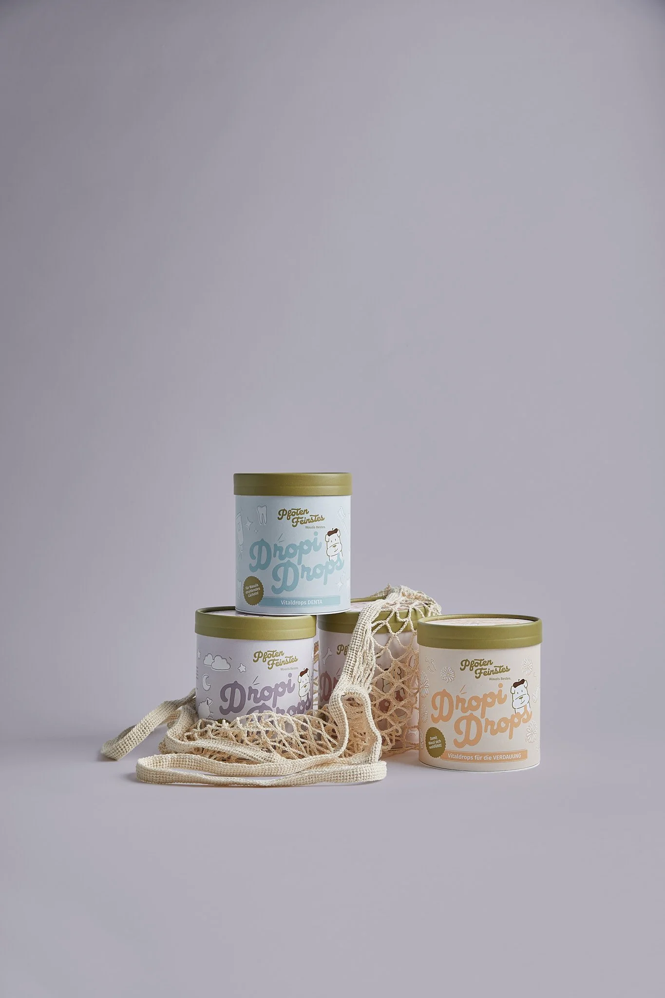 Drei Dosen mit Mineraldrops, dekorativ auf einer weißen Oberfläche, umgeben von einer Stofftasche. Fotografiert von Sarah Neuner.