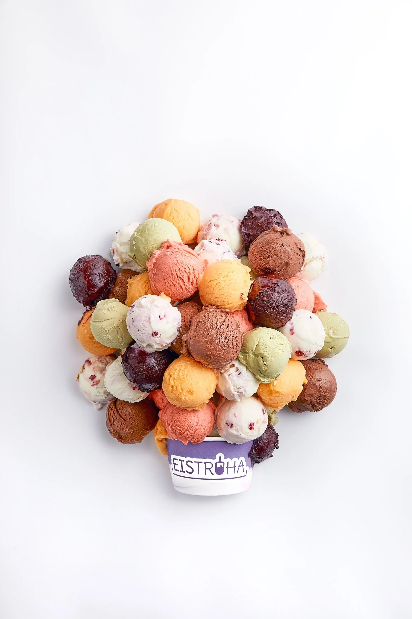 Buntes Eis in einer Eistruhe mit einem Eistüten-Logo, auf weißem Hintergrund. Fotografiert von Sarah Neuner.