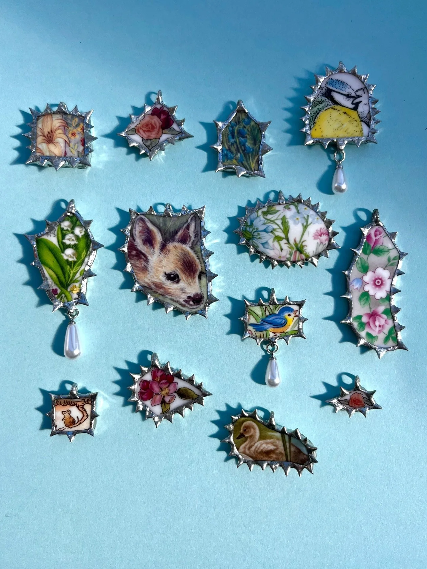 𝕾𝖕𝖗𝖎𝖓𝖌 🧚🏻🪺 All of these pendants have been made out of old ceramics, be it plates, bowls or mugs. By using a traditional stained glass method I&rsquo;ve made the images into objects wearable. ⛓️

🛒 Link in bio