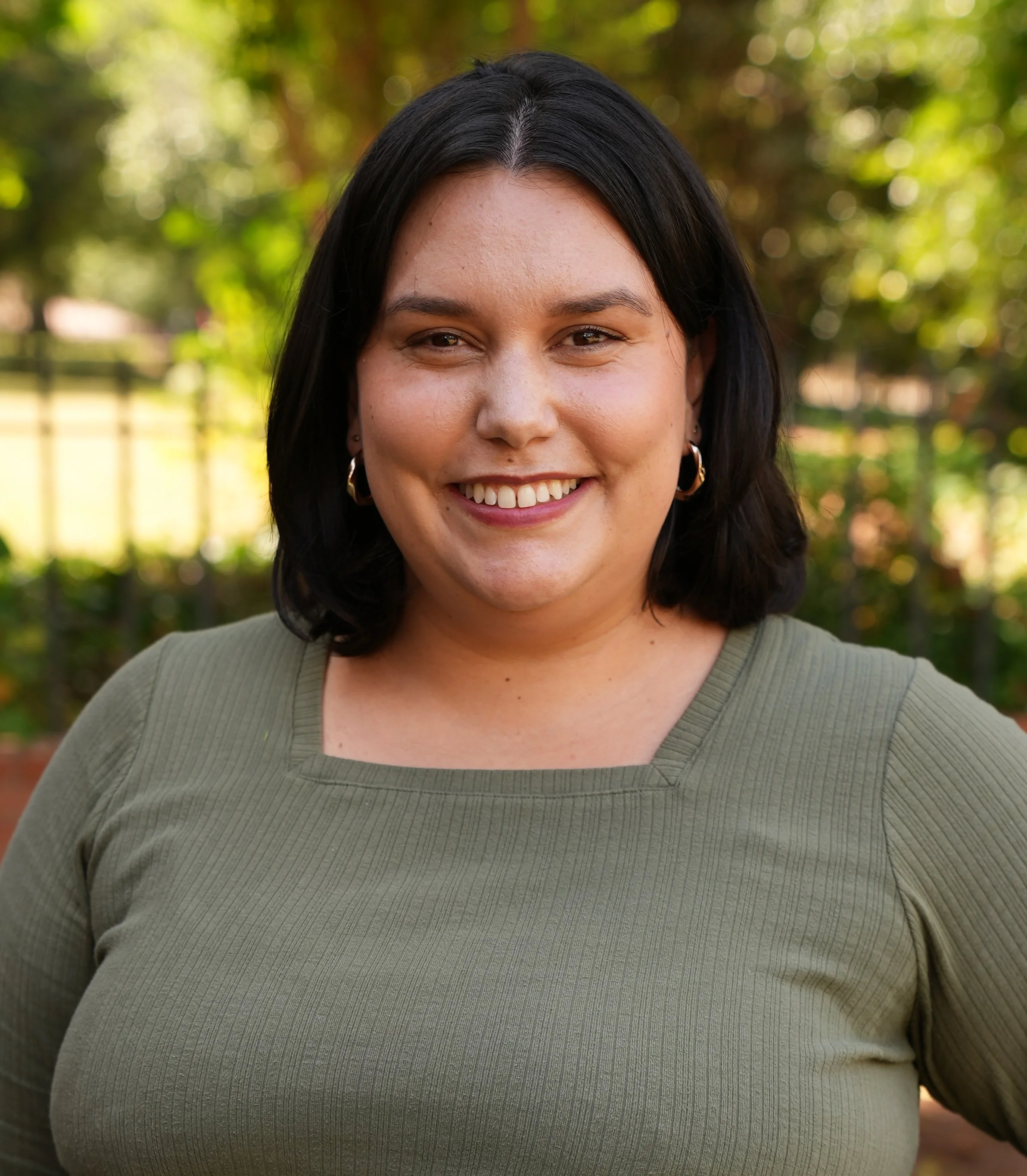 woman with shoulder-length dark hair in a grayish/green shirt