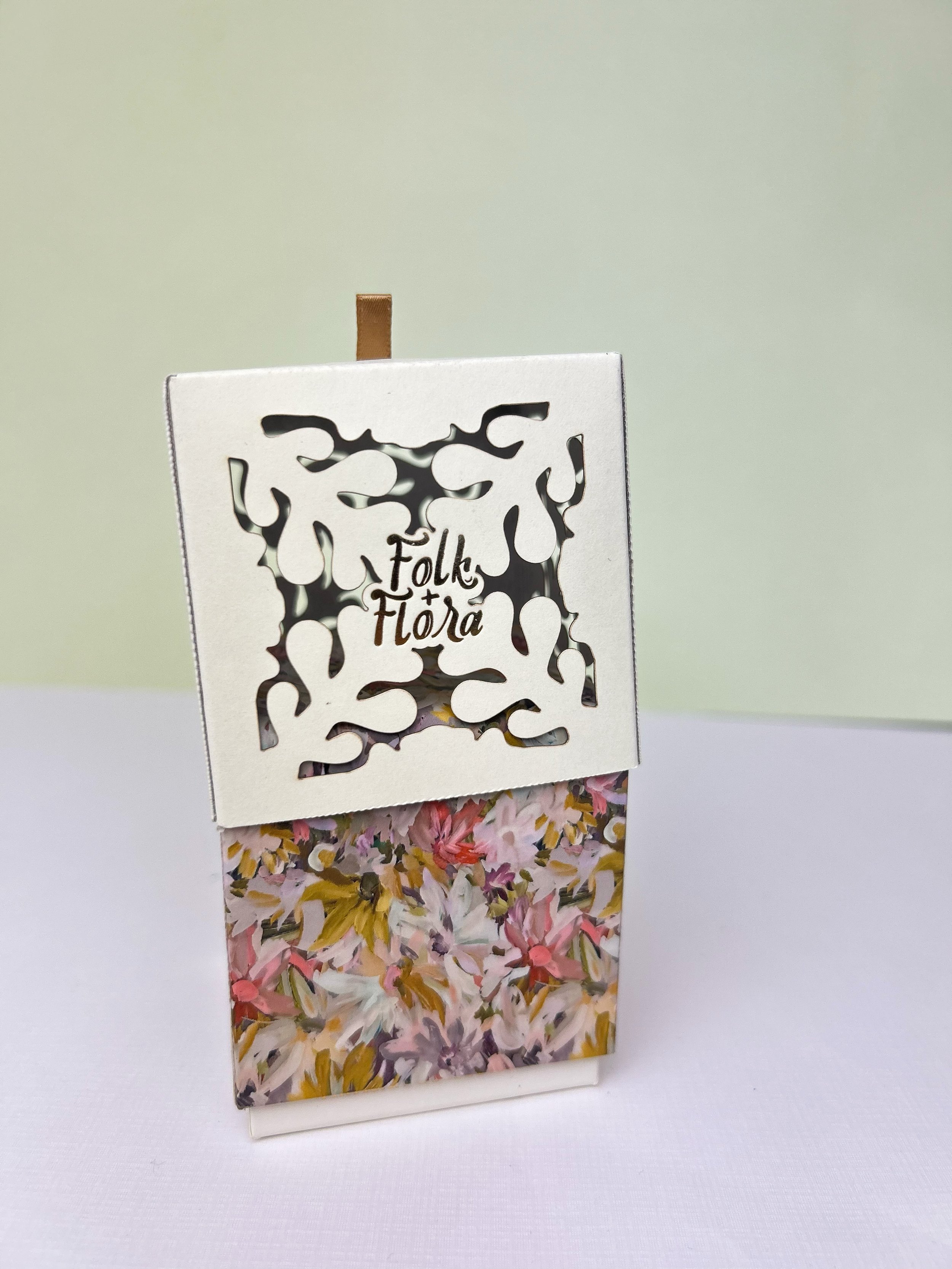 Decorative packaging with "Folk Flora" text and floral design