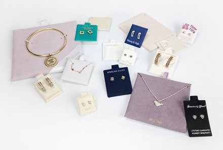 Collection of jewelry and accessories displayed on white background, including bracelets, necklaces, earrings, rings, and packaging boxes.