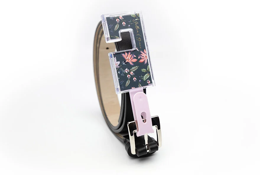 Fashion belt with a floral-patterned buckle and a pink plastic clasp on a white background, molded speciality packaging molded plastic 