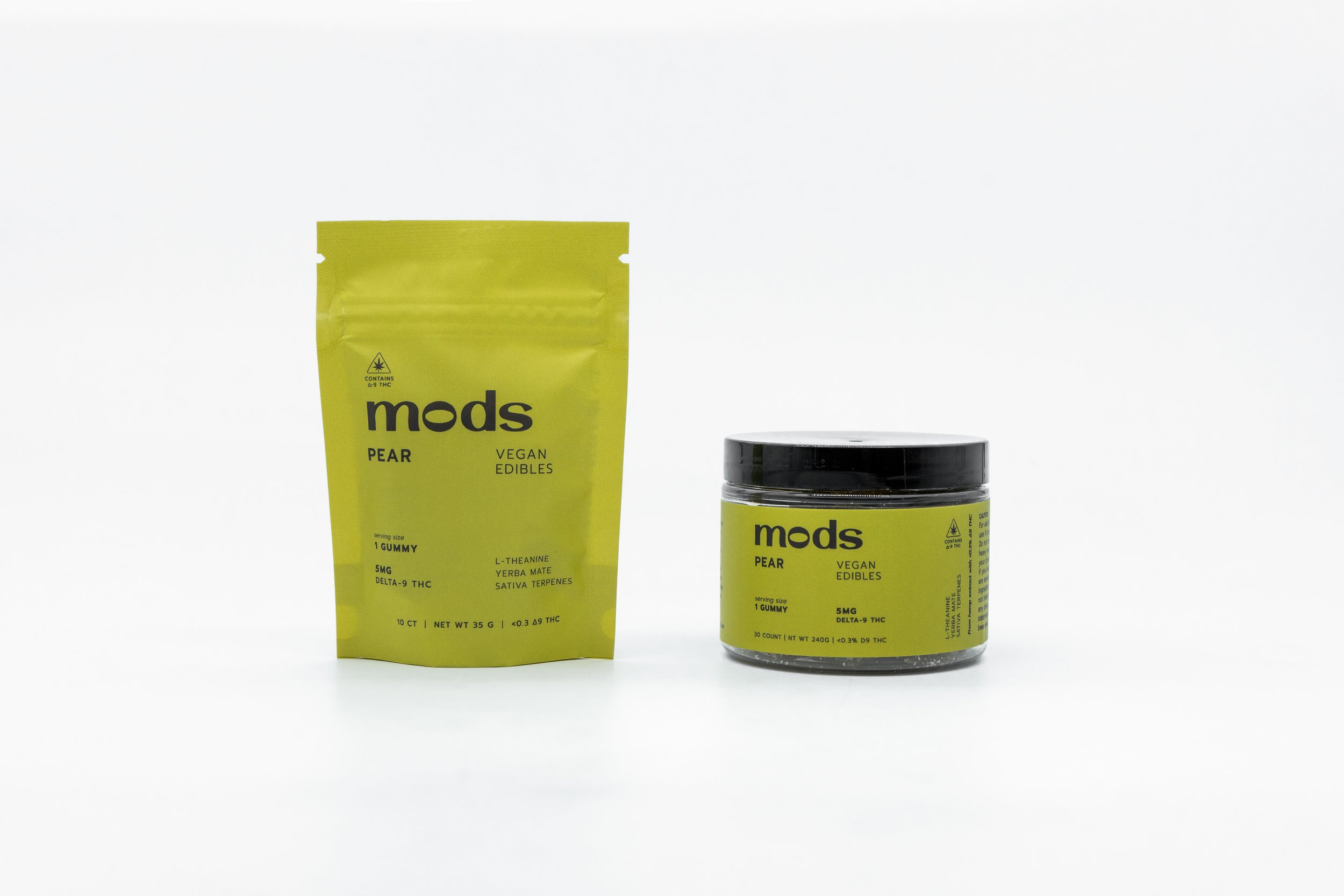 Two containers of Modds vegan edible products, one in a yellow pouch labeled 'Pear' and the other in a yellow jar labeled 'Pear', both with black caps and labels, placed side by side on a white background.