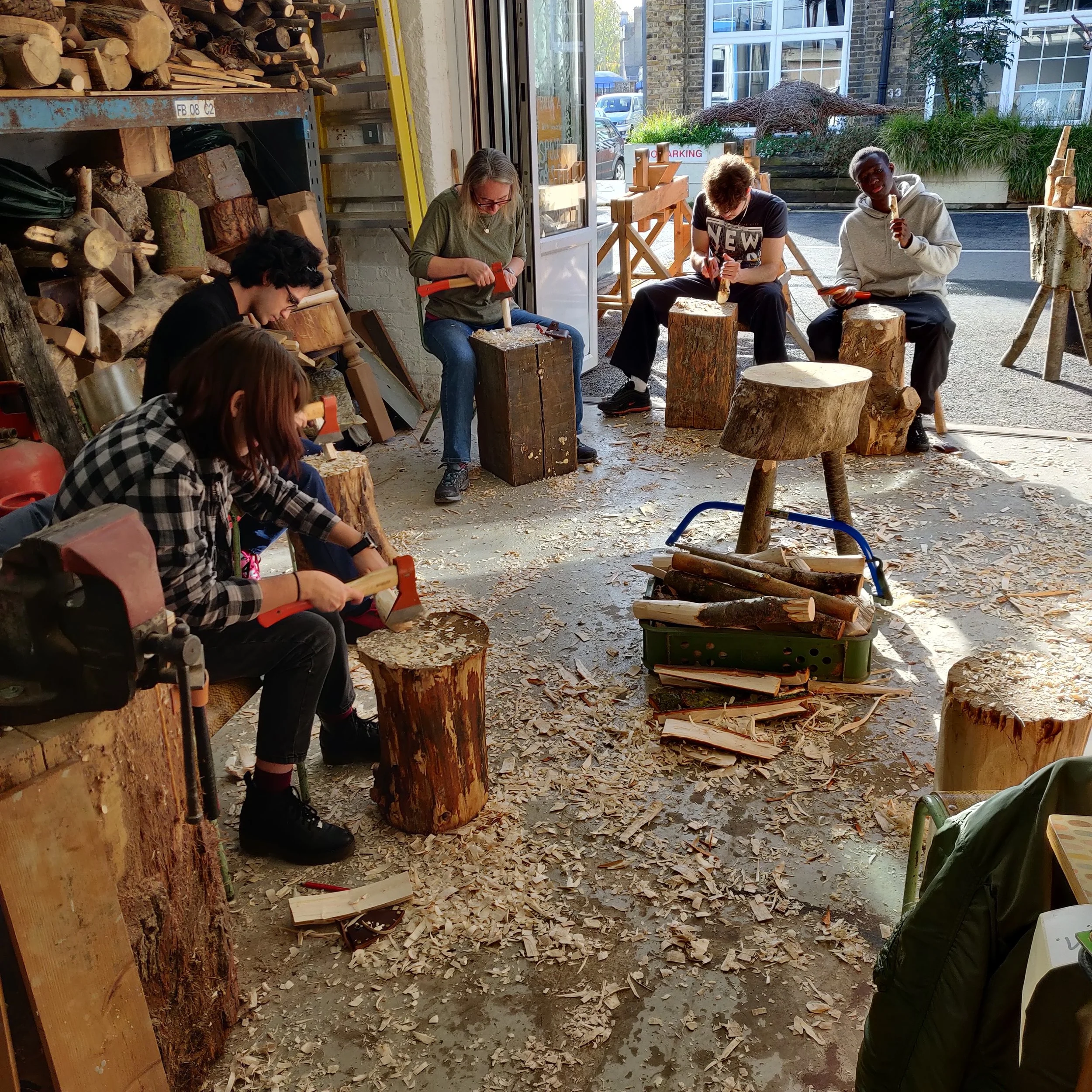 Group of people carving with axes in the studio