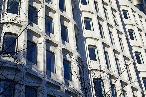 Built in 1974, this Brutalist office block was converted into a trendy hotel, The Standard. 

One of its cool features is a red lift which glides up the front of the building. But what's even cooler is the conceptual design which opted to renovate th