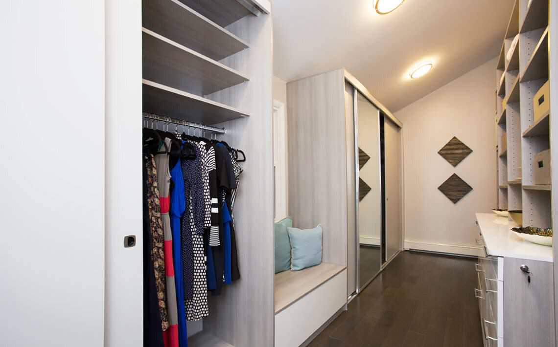  Custom walk-through closet with bench, sliding doors, counter top, and slanted shoe shelves. 