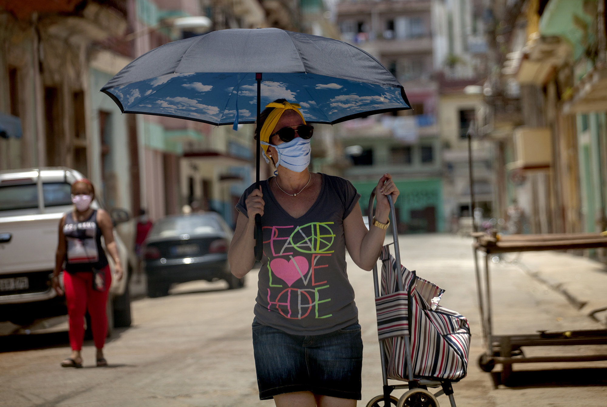  Una mujer con sombrilla en mano, y con el carro de la compra, busca comida en las tiendas cercanas a su casa. Es la rutina diaria de los cubanos, con el Coronavirus el suministro de alimentos y de productos de limpieza cada vez es ms precario.  