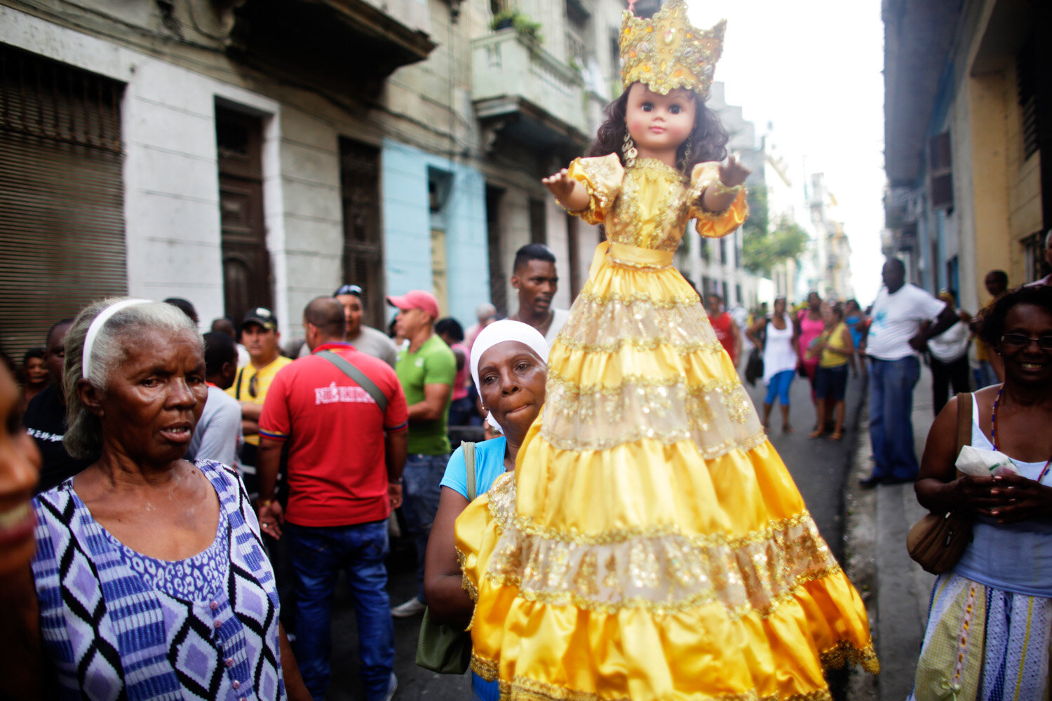  A Cuban woman carries a doll symbolizing Our Lady of Charity saint and at the same time Oshun, Afro-Cuban goddess,  during a procession for Cuba’s patron saint Virgen de la Caridad de Cobre, 2015
                      