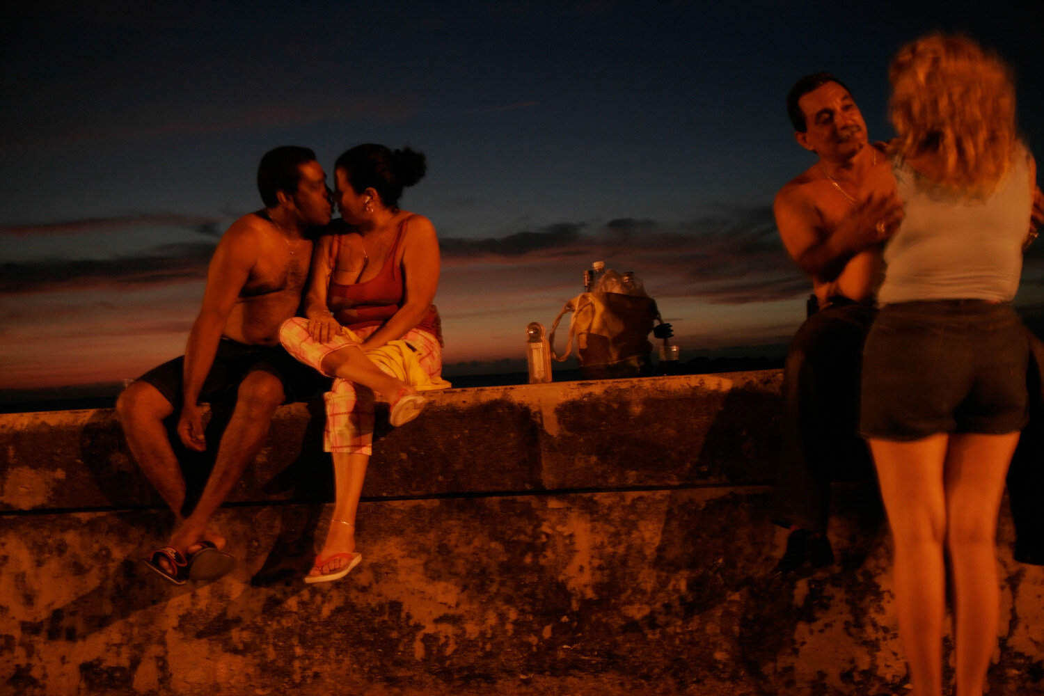  Cuban couples hug and kiss each other after sunset on the wall of Havana's waterfront boulevard Malecon. 