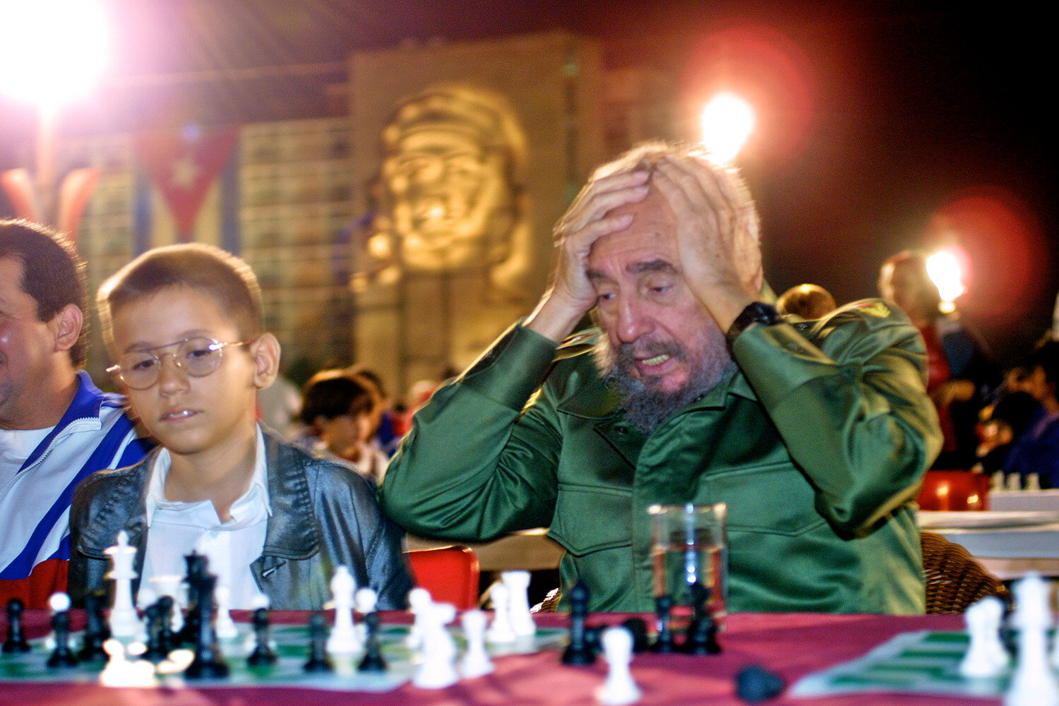  Cuba's President Fidel Castro reacts  during a chess tournament  at the Plaza de la Revolucion, against the backdrop of an image of Che Guevara, on December 7, 2002, in Havana, Cuba. Next to Castro is young Lazaro Castro (not related to Fidel Castro