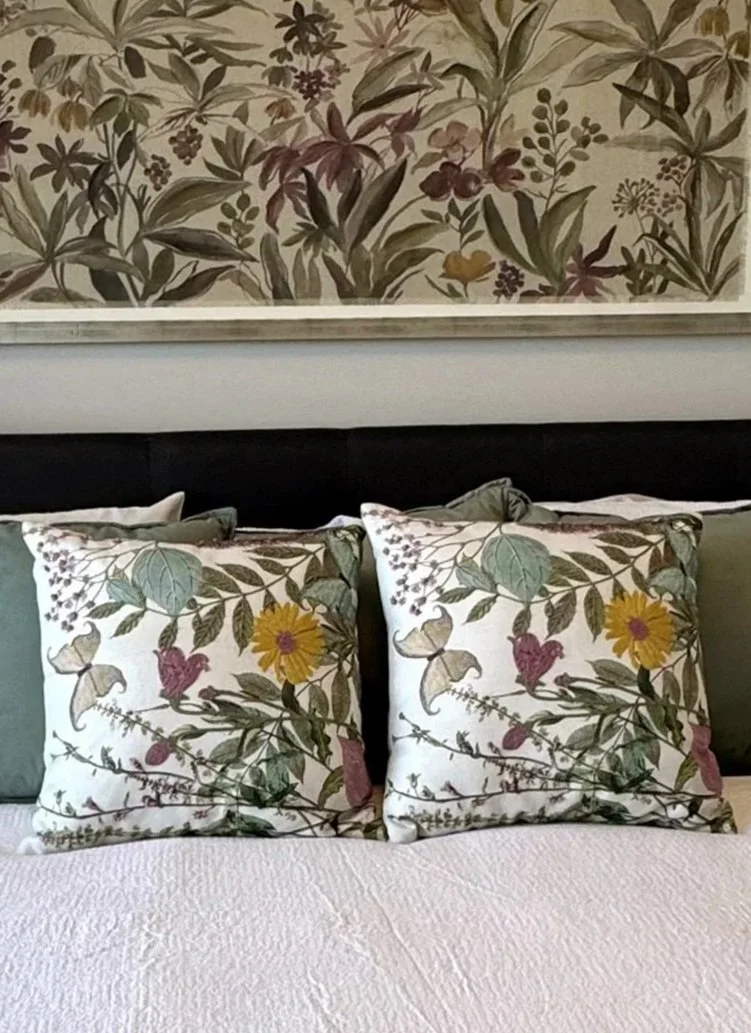 Large floral artwork paired with matching accent pillows adds beauty, comfort, and a sense of luxury to a calm and inviting bedroom design.