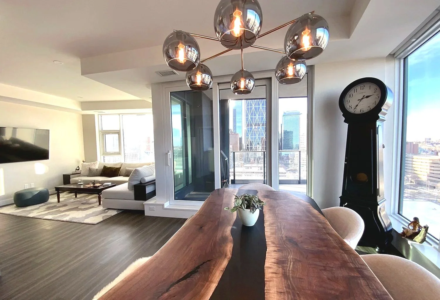 An eclectic condo dining room that blends antique furniture with modern design elements, creating a warm and stylish entertaining space set high above the city with stunning views