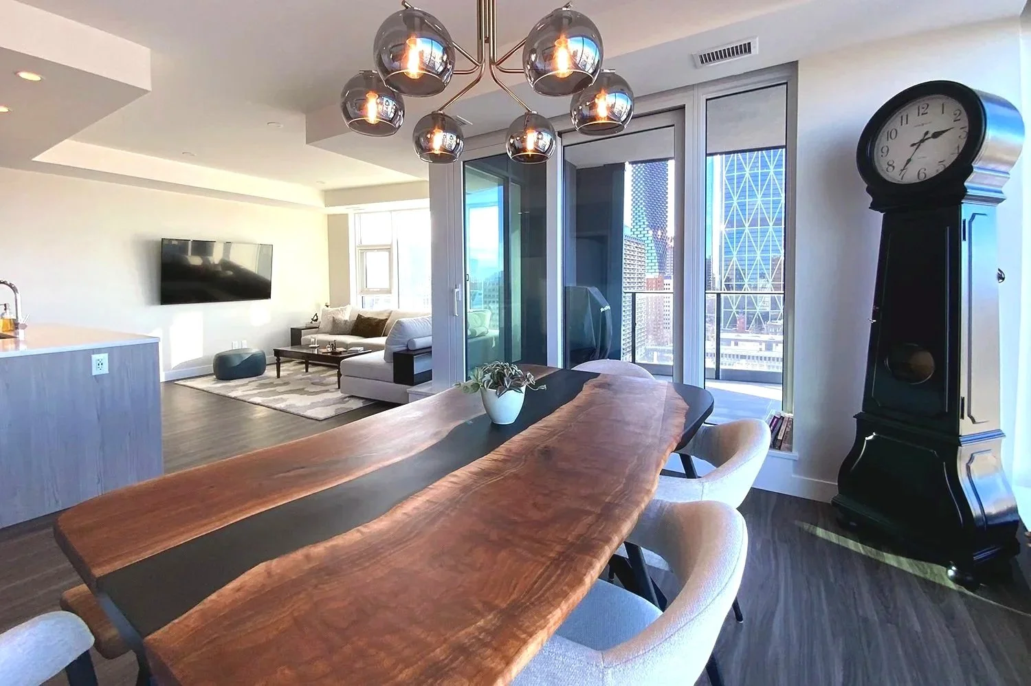 An eclectic condo dining room that blends antique furniture with modern design elements, creating a warm and stylish entertaining space set high above the city with stunning views
