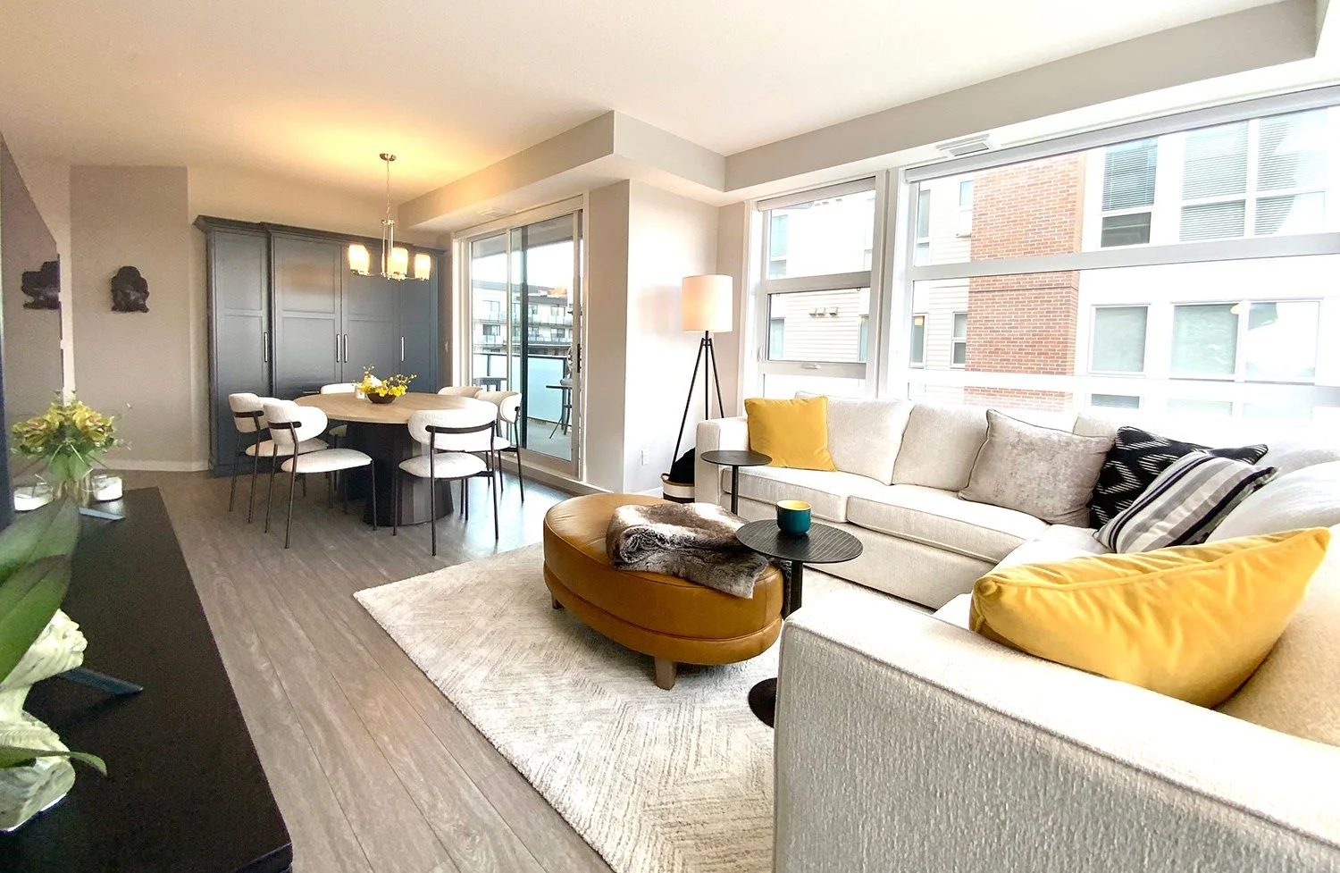 A small condo living room designed with space-saving, proportional furniture to maximize space. Using a neutral colour palette and colourful accents creates an open, airy feel with visual interest.