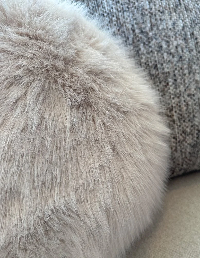 Soft textured pillows in neutral tones add warmth, comfort, and visual texture to a cozy interior space