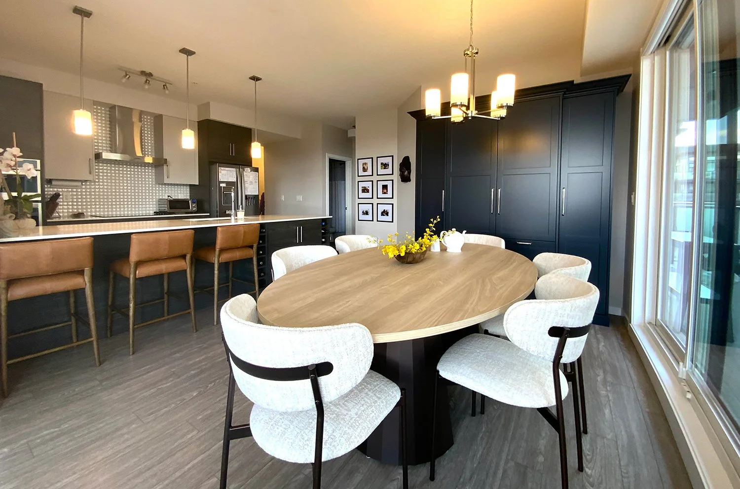 A small condo dining room designed with space-saving, proportional furniture to maximize space. Using a neutral colour palette with black accents creates an open, airy feel with high visual visual impact