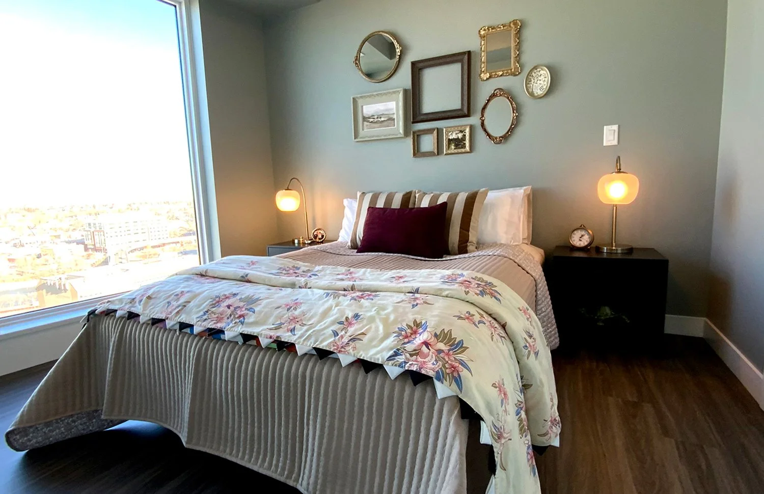 This green bedroom design features a handmade quilt and a salon-style gallery wall of antique picture frames, creating an eclectic space rich in character and warmth