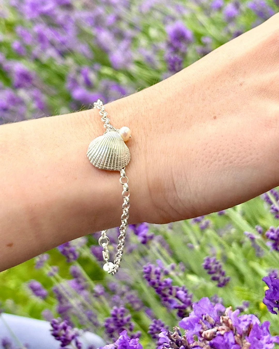 Sea Shell Bracelet - Sterling Silver - one natural cockle shell charm with ivory pearl - worn on model in a lavender garden