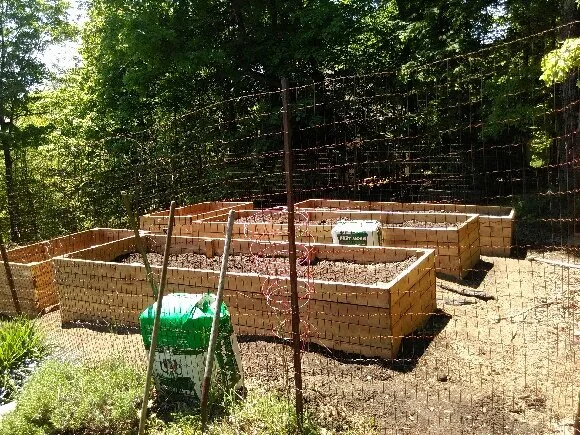 Raised garden beds with wire fencing around them. Created by Unique Landscape and Farming