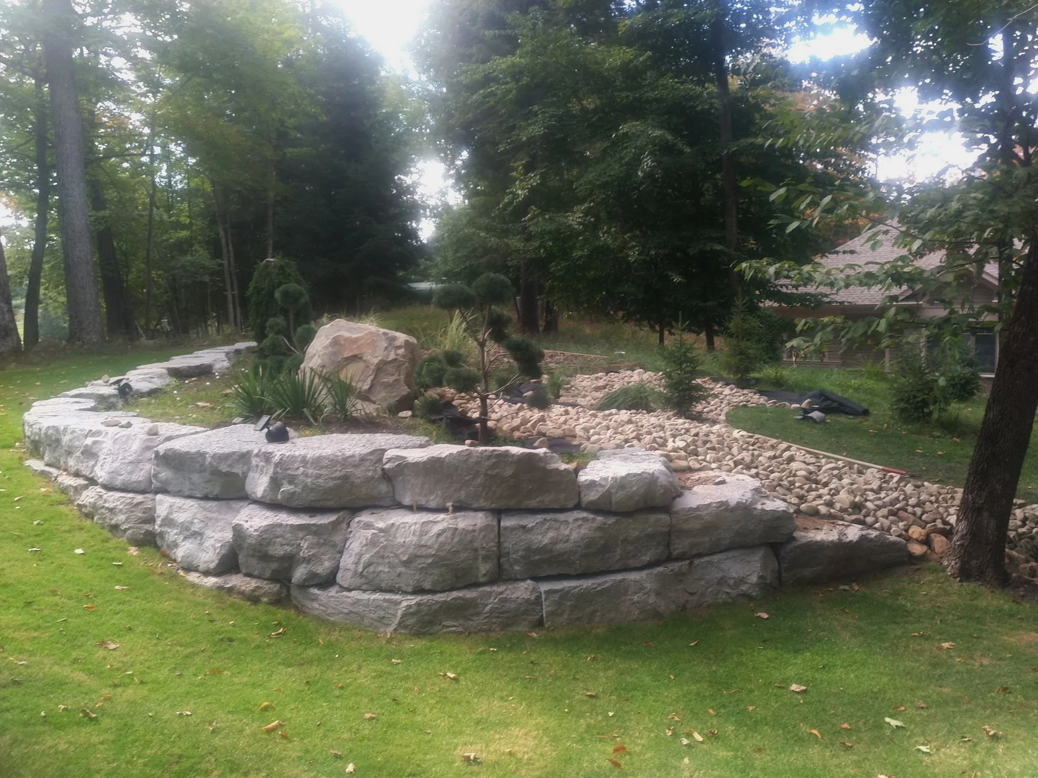 Stone retaining wall with rock accents