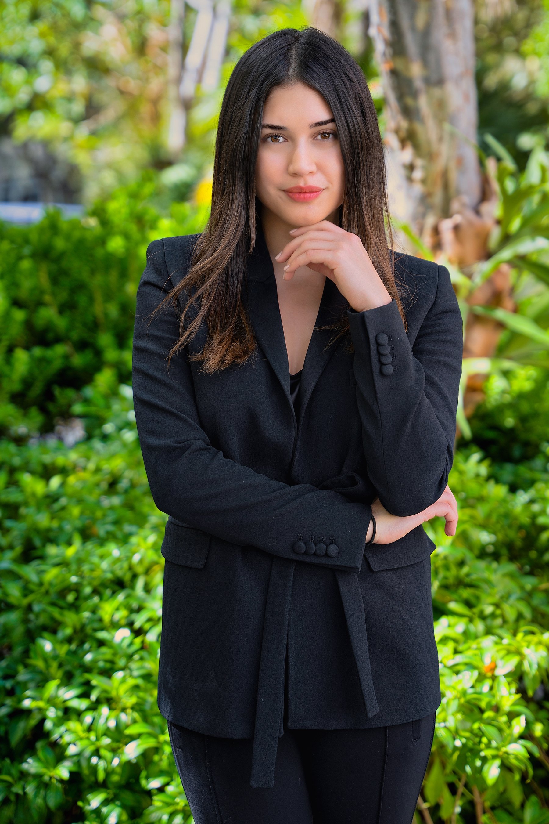 Woman in a black blazer standing in a garden