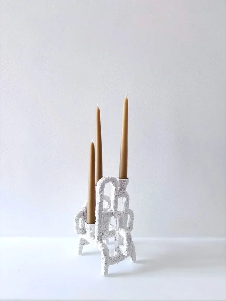 Decorative white candle holder with threeyellow beeswax candles