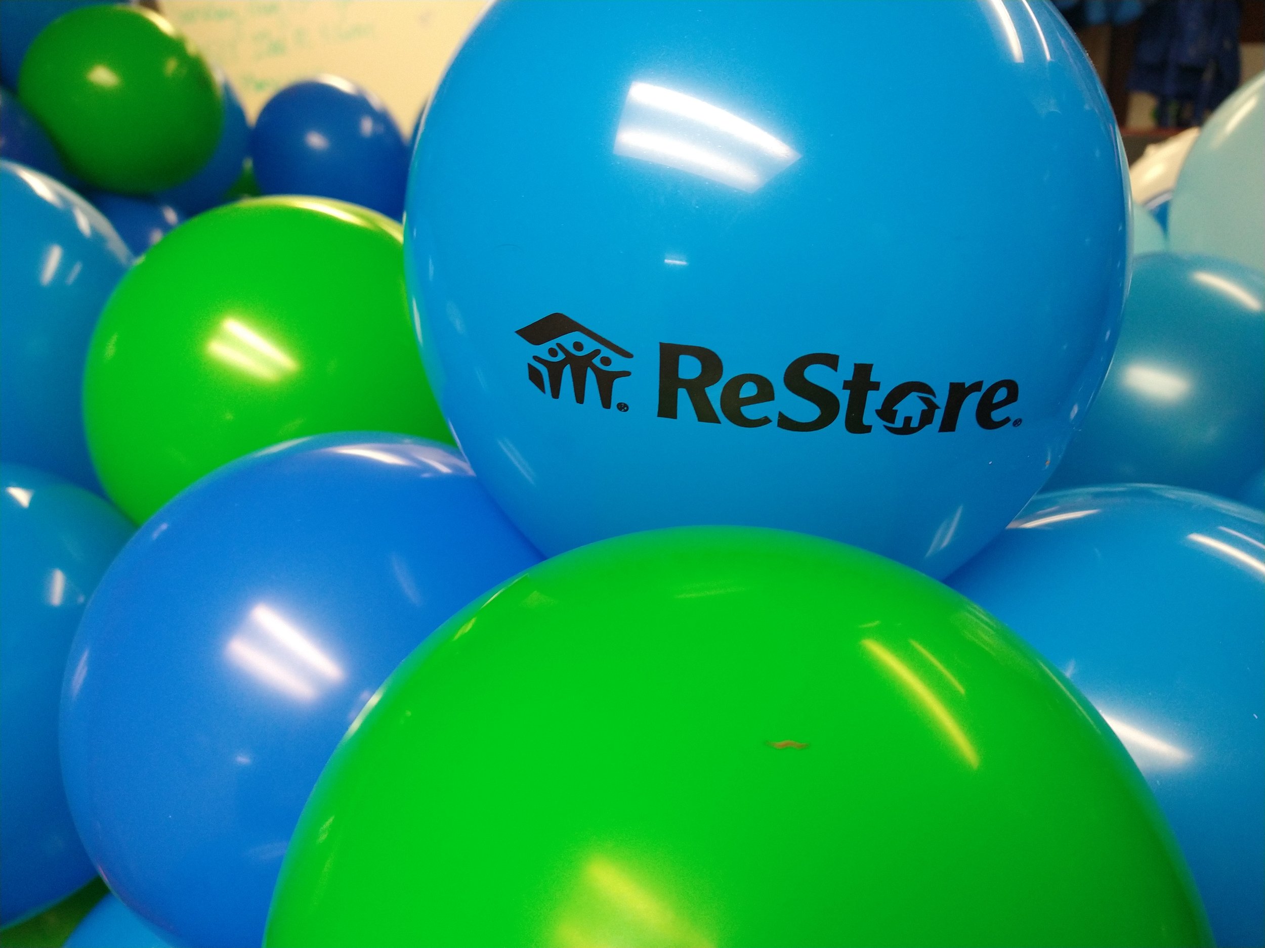 Green and blue balloons with the ReStore logo