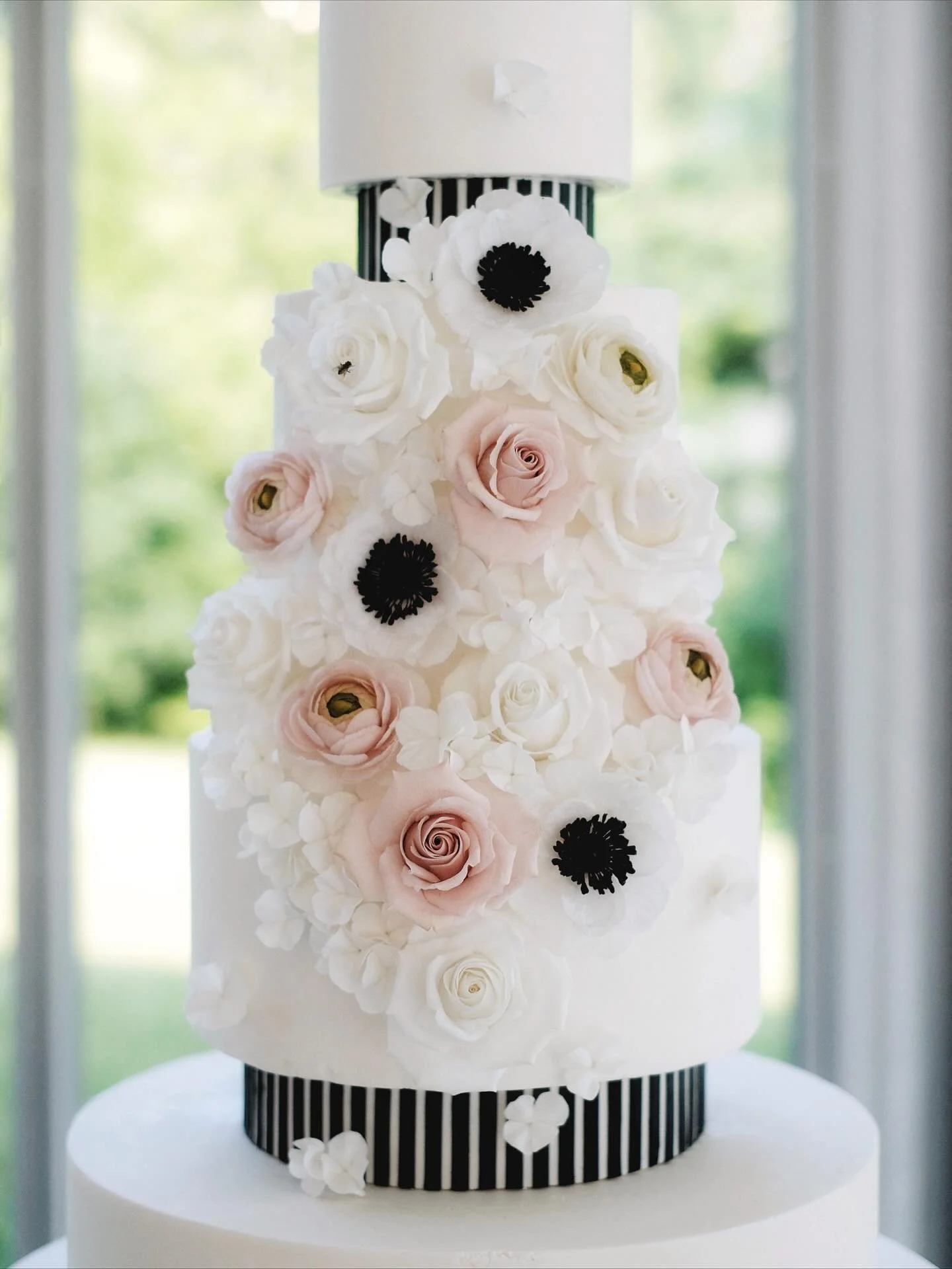 Soft petals, delicate textures, and hours of hand-crafted sugar work 🤍 

This cake was such a dream to bring to life &mdash; layers of blush roses, anemones, and tiny hydrangeas all made from sugar, wrapped around a clean modern black and white silh