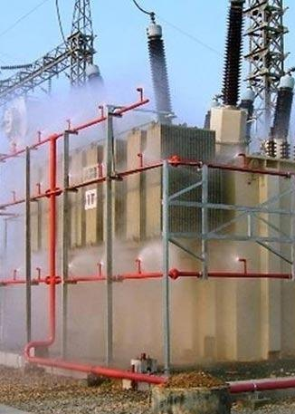 Transformateur électrique avec système de refroidissement à eau, entouré de tuyaux rouges dans une station électrique.