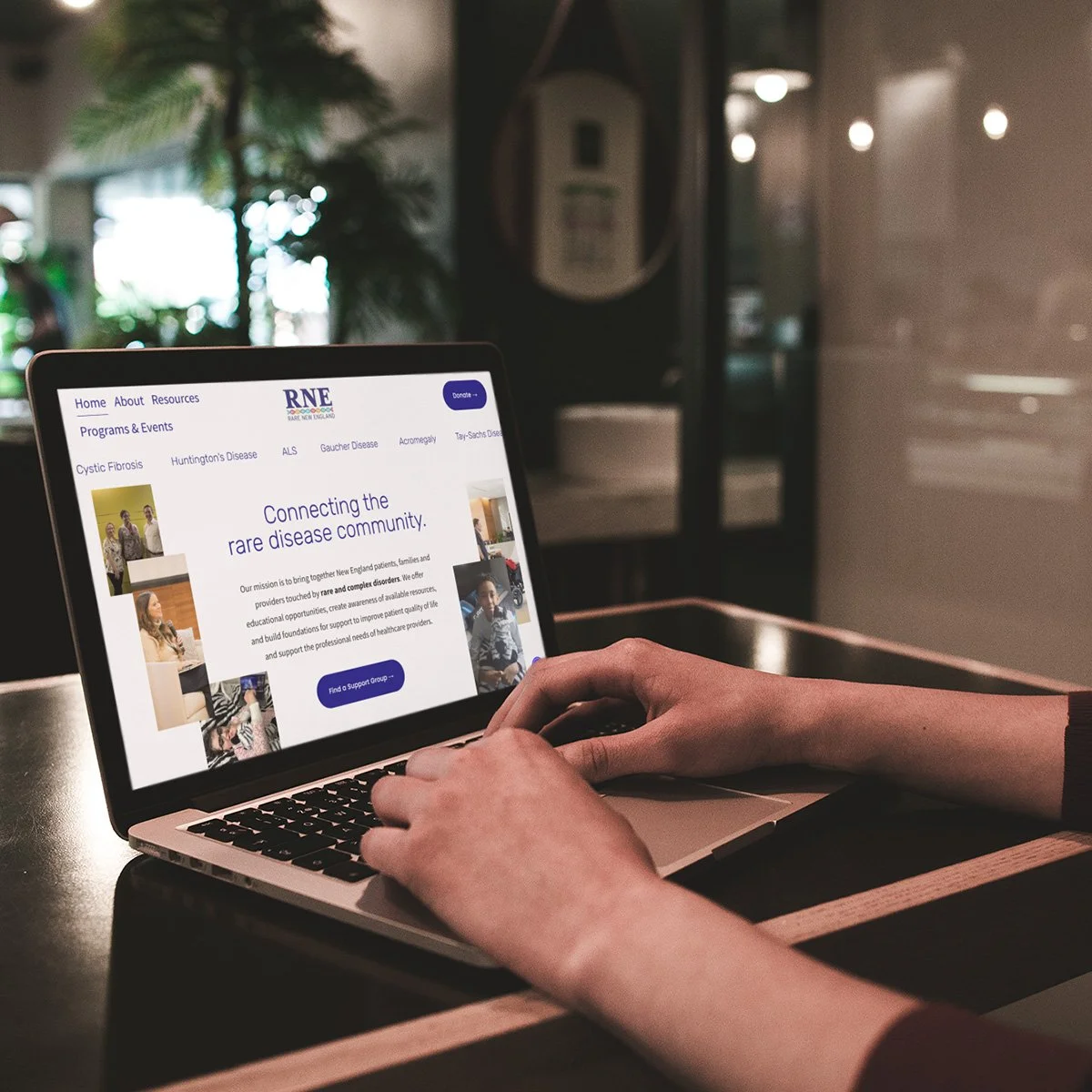 A person using a laptop at a table, browsing the Rare Disease Network website focused on connecting the rare disease community.
