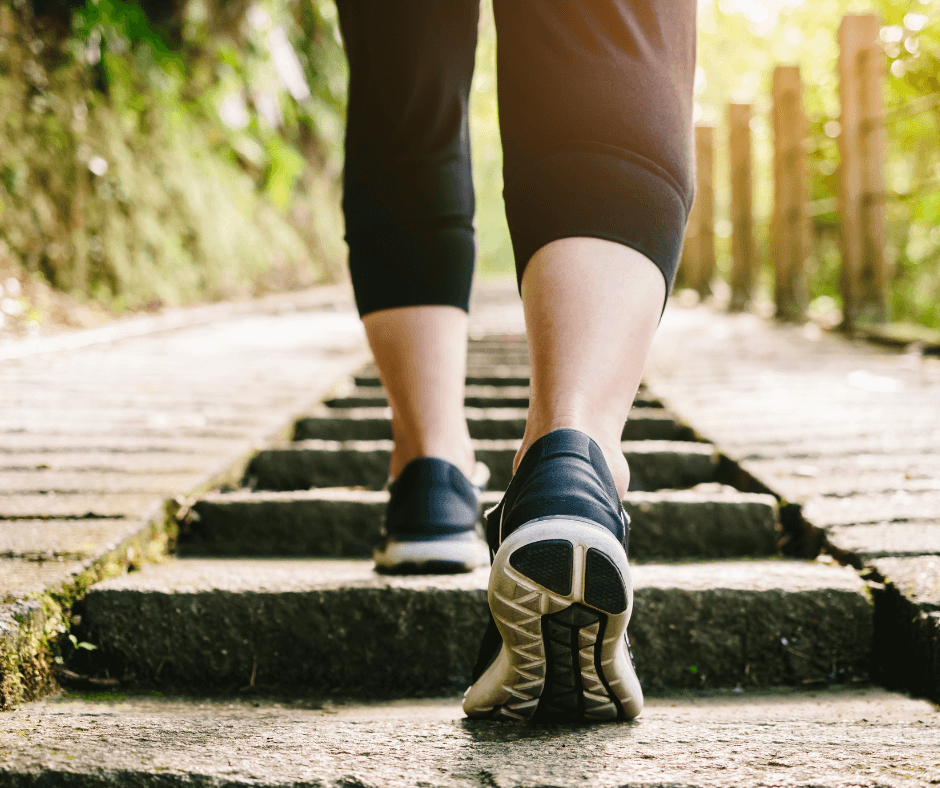 InHouse Pilates blog The benefits of being active image woman walking outdoors up stairs.