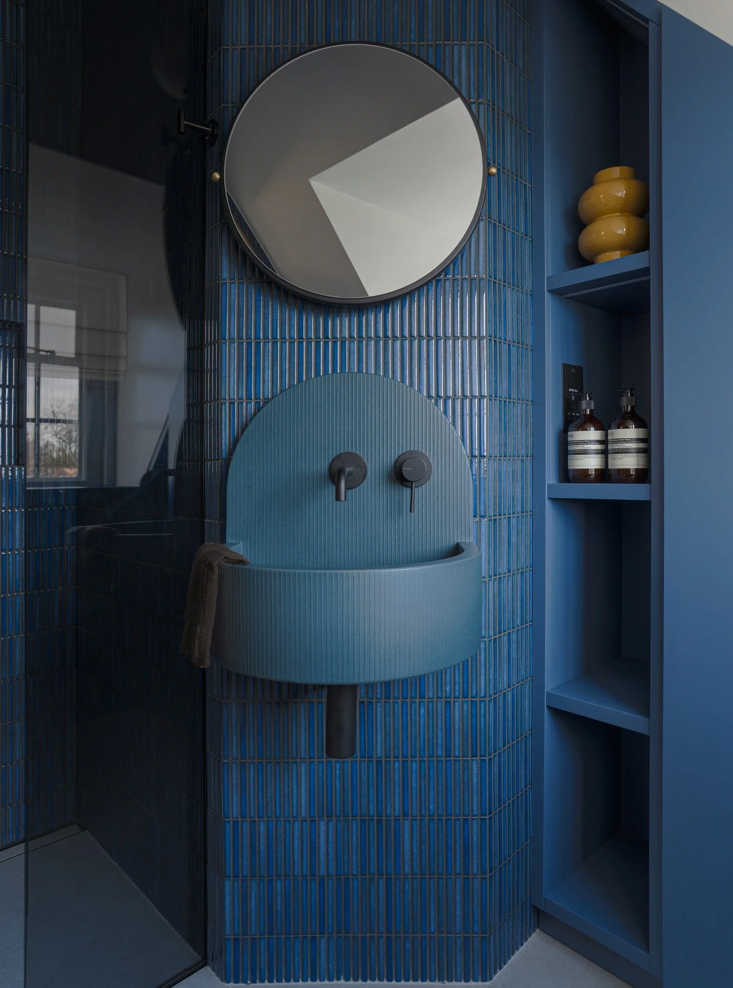 🔵 Bold in Blue 🔵

In this beautifully moody space by @axent_studio, our Elma basin becomes part of the architecture itself. Framed by glossy vertical tiles, softened by warm lighting and grounded with dark brass fittings, the palette feels deeply i