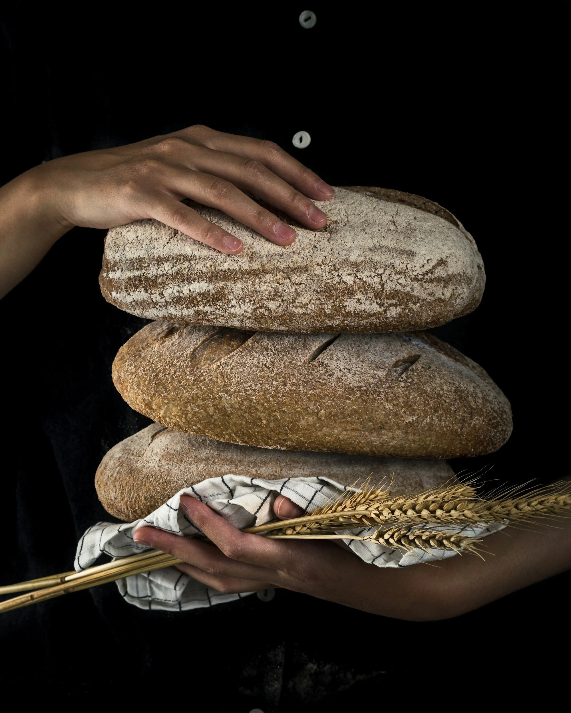 Person som håller i ett nybakat bröd för catering och måltider i Stockholm