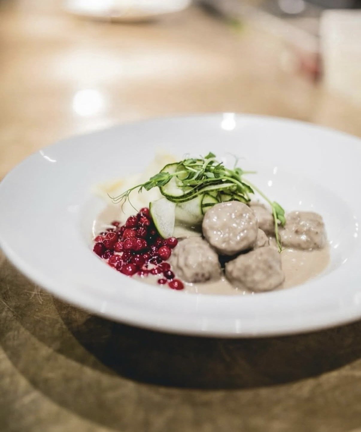 Klassiska svenska köttbullar med potatismos, gräddsås, lingon och pressgurka för catering i Stockholm