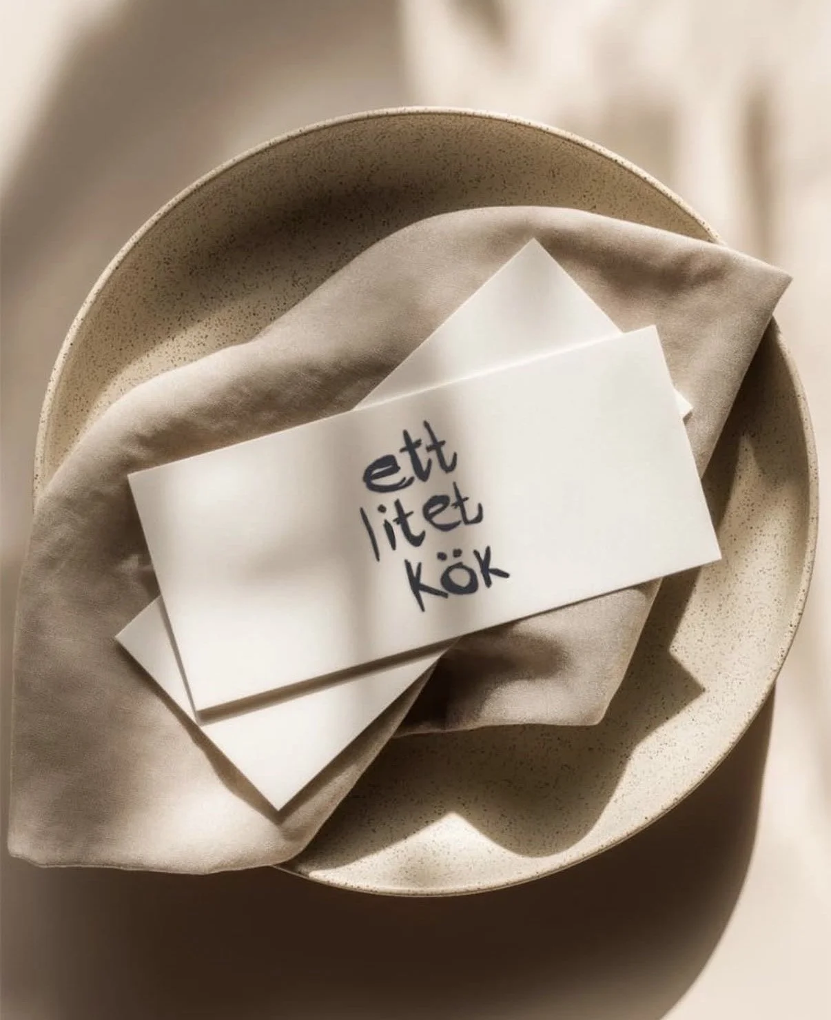 Visitkort från Ett litet kök på en tallrik vid en dukad cateringdukning