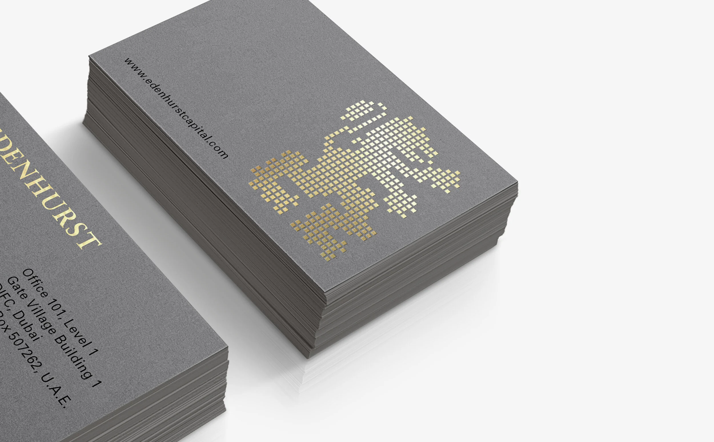 Stack of business cards with gray background, gold pixelated number 2024, and website edenhurstcapital.com.