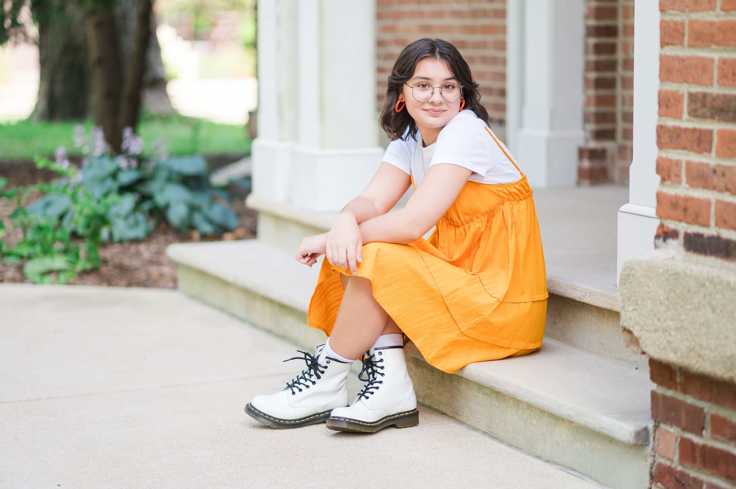 Editorial senior portrait of a teen at a local college campus, mixing structured hardscape with personal style.