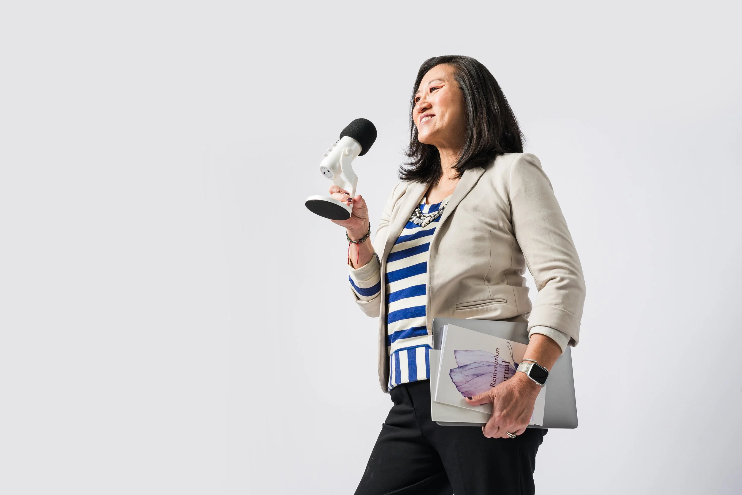 solo business owner and author holding podcast microphone and book